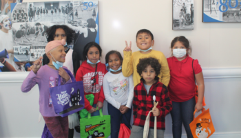 A group of children holding Halloween bags and smiling