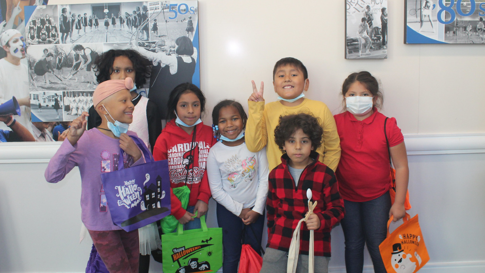 Blog Post Featured Image (1000 × 563 px) A group of children holding Halloween bags and smiling