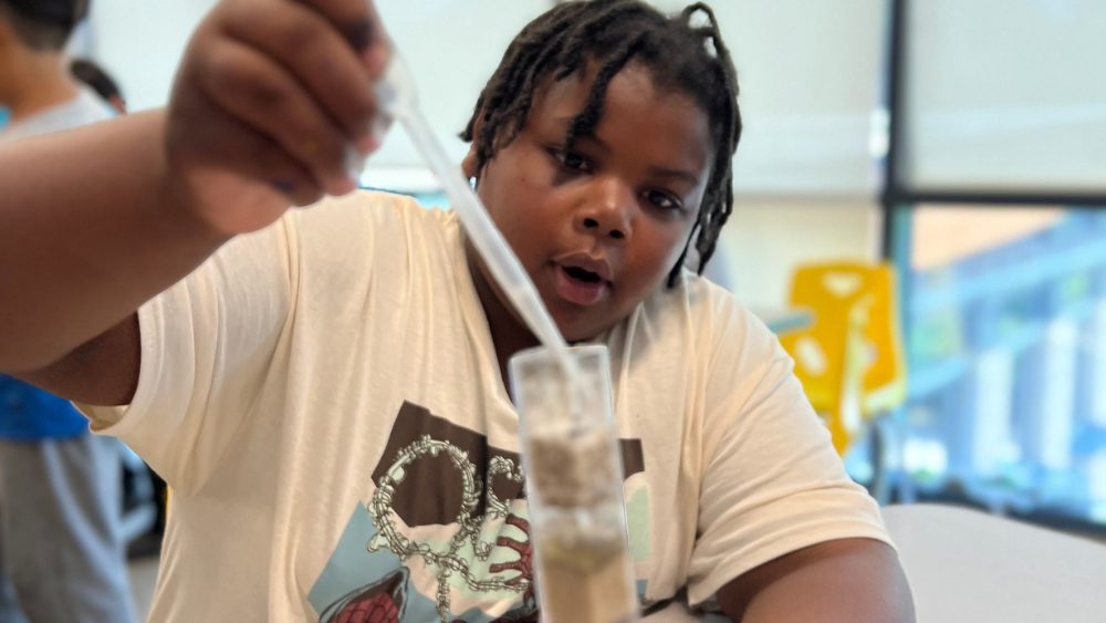 2024 Camp highlights blog featured images(3) A photo of a student carefully dripping water into an upright water filtration system