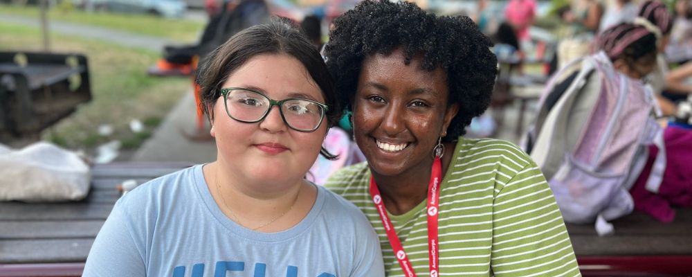 A photo of an AmeriCorps member and a student smiling