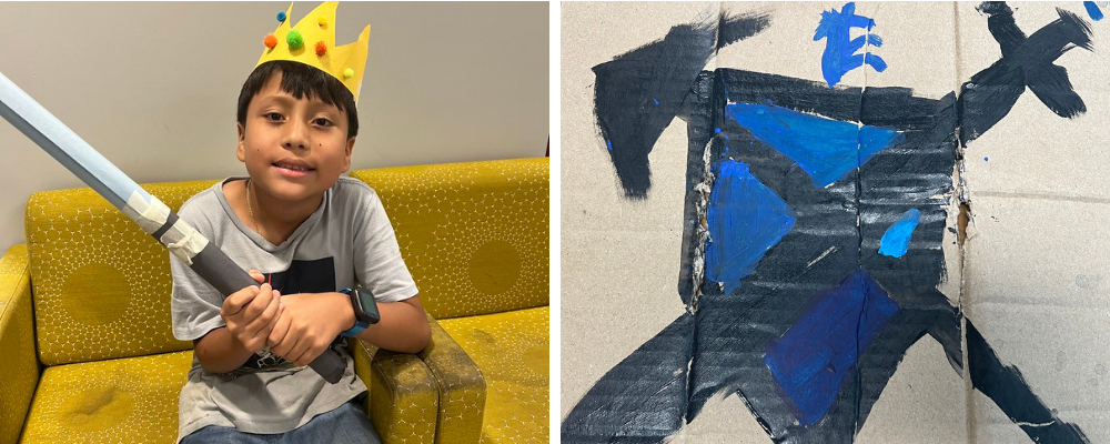 Student in a homemade crown and a shield painted on cardboard