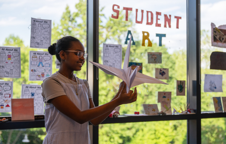 A student holding a paper crane