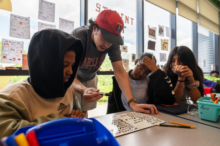 An instructor explaining a concept to three students