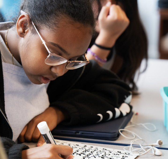 A student writing on a handheld whiteboard