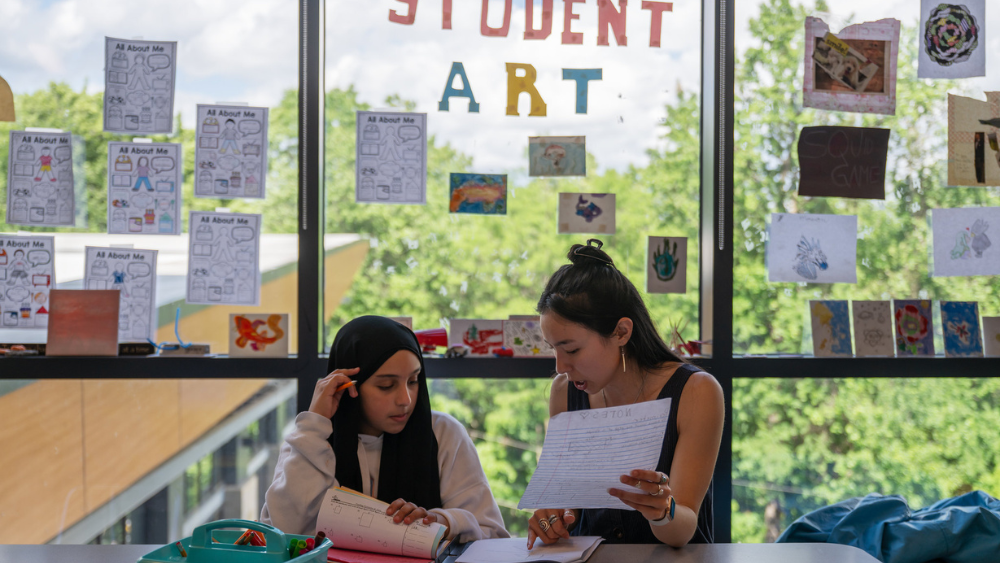 A photo of Dakota working with a student